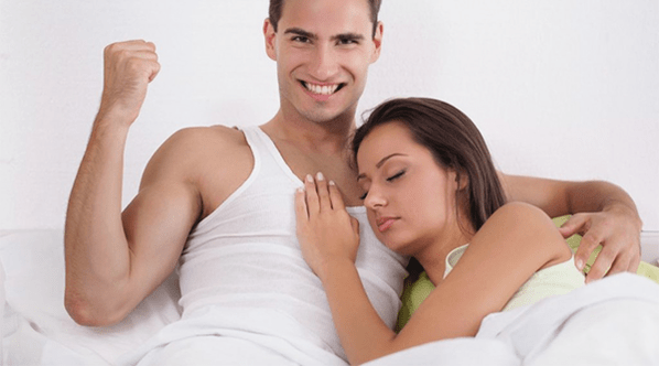 ženska v postelji z moškim, ki ima povečano potenco